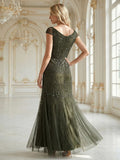 Karena Dress Juniper - Order In, a fitted cap sleeve dress with sequins, showcased from the back in a grand indoor setting.