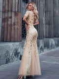 gold formal dress with tulle overlay and leaf design